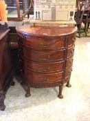 A reproduction mahogany demi-lune chest, the top with radiating inlay over twelve drawers, raised on