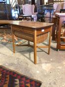 A mid century vintage teak sewing table, with single drawer and sliding well, raised on square