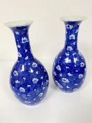 A pair of Oriental blue and white baluster vases with crimped tops, decorated with stylised floral