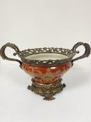 A modern porcelain brass mounted two handled jardiniere with pierced border raised on socolo cast