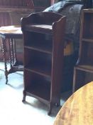 An Edwardian mahogany open bookcase, with blind fret carving and three shelves, raised on shaped