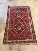 Persian design red ground rug, with double lozenge medallion within geometric border 83cm x 139cm