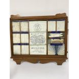 An Edwardian oak framed presentation sample cabinet, the bleached calico by Rylands & Son Ltd. Grand