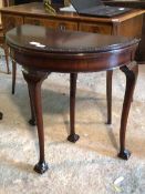 A Chippendale design mahogany demi-lune fold over card table with baize lining and ball and claw