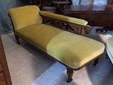 A Late Victorian beech framed chaise longue, upholstered in velvet, with fret cut open arm and