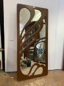 A painted wall hanging mirror of Art Nouveau design, the rectangular mirror plate with fret cut