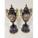 A pair of Vienna porcelain two handled urn style vases complete with covers, with oval overpainted