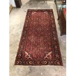 Persian design red ground runner rug, the field with allover stylised floral design enclosed by