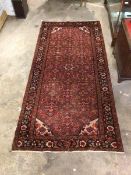 Persian design red ground runner rug, the field with allover stylised floral design enclosed by