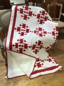 A 1920s comfy quilt, with stylised red urn design and red border, 216cm x 184cm