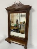 An Edwardian walnut shaving mirror with arched carved surmount and bevelled glass plate, with open