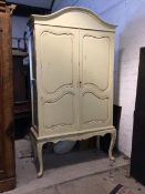 French style cream painted armoire on stand, the domed top over two panelled doors enclosing hanging