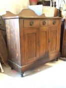 An Arts and Crafts period stained pine sideboard, the raised back over three drawers and two