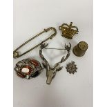 A white metal stag's head brooch, a white metal hardstone brooch (a/f), a cap badge, a white metal