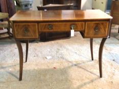 A Regency style cross banded mahogany side table, with three drawers, raised on sabre supports