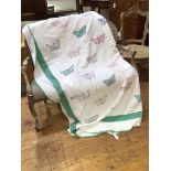 A 1920s a comfy quilt with butterfly design, and green border, border loose and worn at corners -