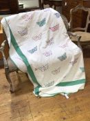 A 1920s a comfy quilt with butterfly design, and green border, border loose and worn at corners -
