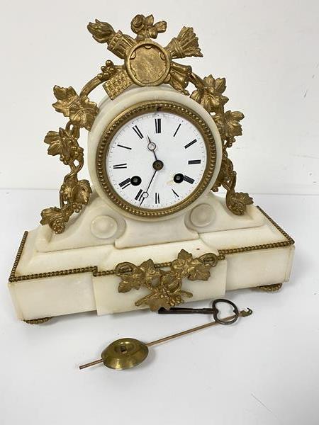 A 19thc alabaster metal mounted drum head clock with enamelled dial and twin key apertures, complete