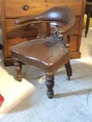 A Victorian carved oak library tub chair, upholstered in studded faux leather, raised on turned