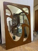 A painted wall hanging mirror of Art Nouveau design, the rectangular mirror enclosed by a fret cut
