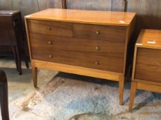 A mid 20th century teak veneered chest, fitted with two short and two long drawers, raised on square