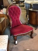 A Victorian style mahogany framed spoon back slipper chair, floral crest rail over button back