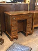 A Quality 20th century figured walnut knee hole desk, the top inset with tooled leather writing