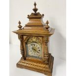 An Edwardian walnut mantel clock with pedimented top with three finials and silvered dial with roman