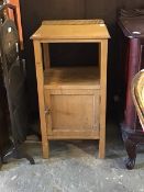 An early 20th century oak bedside cupboard, with raised back over moulded top and open shelf,