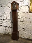 A Westminster Chiming grandmother clock, the arched top above a hinged door before a dial with Roman