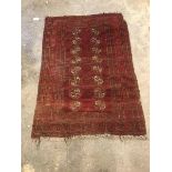 Afghan bokhara red ground rug, with double row of eight guls, enclosed by border with geometric