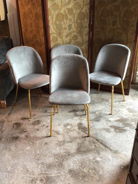 A Set of four contemporary dining chairs, upholstered in grey quilted fabric, raised on tubular