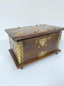An Indian hardwood brass mounted and studded box with hinged top enclosing a plain interior, on