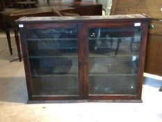 A 19th century mahogany bookcase, with two glazed doors enclosing three shelves, formerly the top