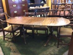 A reproduction Regency design twin pillar dining table, the cross banded oval top with reeded edge