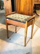 An Edwardian hardwood framed music stool, with upholstered hinged seat raised on square tapered