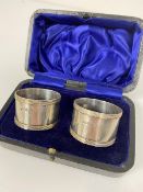 A pair of Sheffield silver napkin rings with banded borders, complete with original fitted case (