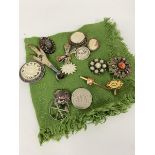 A collection of brooches including a ptarmigan's foot, mother of pearl mounted white metal brooch, a