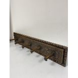 A late 19thc/early 20thc oak rectangular wall mounted coat rack fitted five pegs with relief