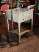 An early 20th century painted lamp table, the top with inset glass panel over two drawers, raised on