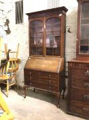 An Edwardian mahogany bureau bookcase, the top with blind fret frieze over two glazed doors