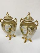 A pair of Noritake ovoid two handled urn style vases with pierced tops, one knop a/f, with twin