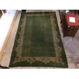 An early 20th century Arts and Crafts Donegal style green ground carpet, the central field