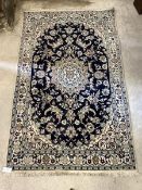 A Persian design ground rug, the blue field with ivory medallion and interlaced trailing foliate,