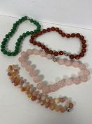 A group of four polished stone bead necklaces, all approximately 23cm