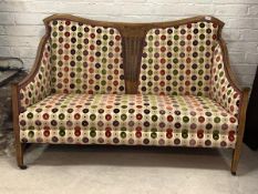 An Edwardian inlaid mahogany settee, upholstered in a contemporary fabric, raised on square