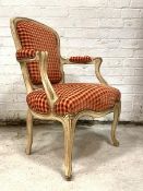 A French Fauteuil chair, the white painted frame enclosing checked upholstery, raised on cabriole