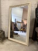 A Large cream painted wall hanging mirror, with floral moulded frame enclosing bevelled mirror 115cm