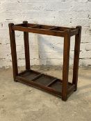 An early 20th century stained walnut two division stick stand on stile supports H75cm, W76cm, D28cm