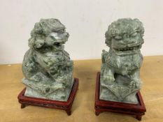 A pair of Chinese carved stone lions, each on wooden stand (13cm)